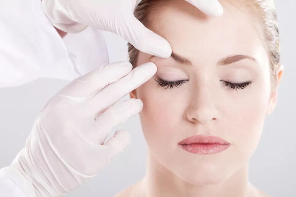Aesthetic expert checks the skin around the eyes